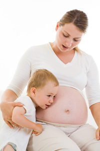 Imagen de mujer embarazada junto a niño