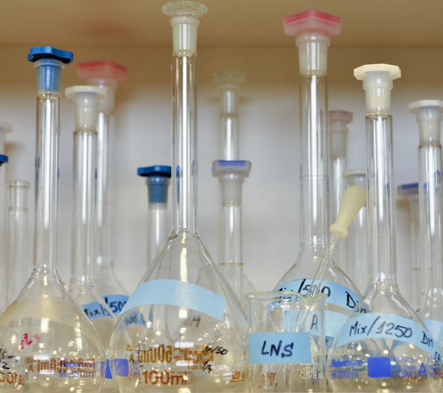 Mesa de laboratorio con diferentes botes de pruebas de cristal