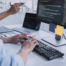 Manos de un hombre sobre el teclado de un ordenador mientras realiza un Red Team, ejercicio de simulaci&oacute;n de un ataque sobre la infraestructura de una organizaci&oacute;n. 
