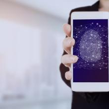 Esku baten irudia, telefono mugikor baten pantaila erakusten duena. Bertan, hatz-marka baten irudia ageri da, aplikazioen kontrol eta konfigurazio segurua irudikatzen duena.