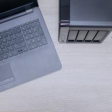 Ordenagailu eramangarri bat, kanpoko disko gogor batean segurtasun-kopia bat egiten ari zaiona.