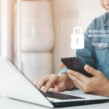 Gizon batek, eskuan, giltzarrapo baten irudia duen mugikor bat dauka, bere datu pertsonaletara sartzeko.