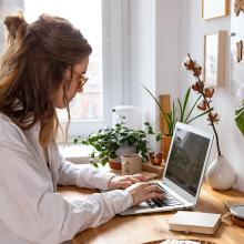 Una mujer escribe en un ordenador portátil sobre el riesgo del BYOD (Bring your own device).
