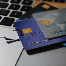 Imagen de varias tarjetas de cr&eacute;dito encima de un teclado, que representa el malware bancario.