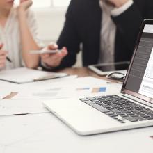 Unas personas sentadas en una mesa hablando sobre el Esquema Nacional de Seguridad, ENS.