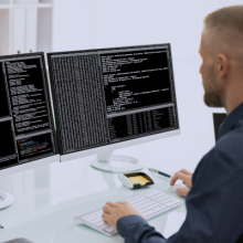 Un hombre frente a la pantalla de un ordenador, monitorizando la seguridad industrial de una empresa.