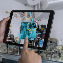 Manos de un técnico en diseño e implantación de arquitecturas seguras en redes industriales sosteniendo una tablet.