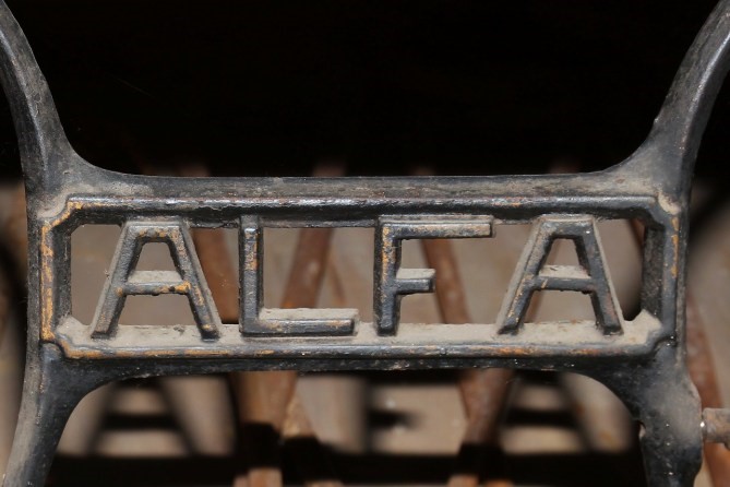 Detalle de la marca Alfa en la estructura de la máquina de coser.