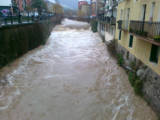 Se muestra una crecida dentro de un pueblo, contenida, la corriente es r&aacute;pida, arrastra mucho barro, por lo que la peligrosidad aumenta.