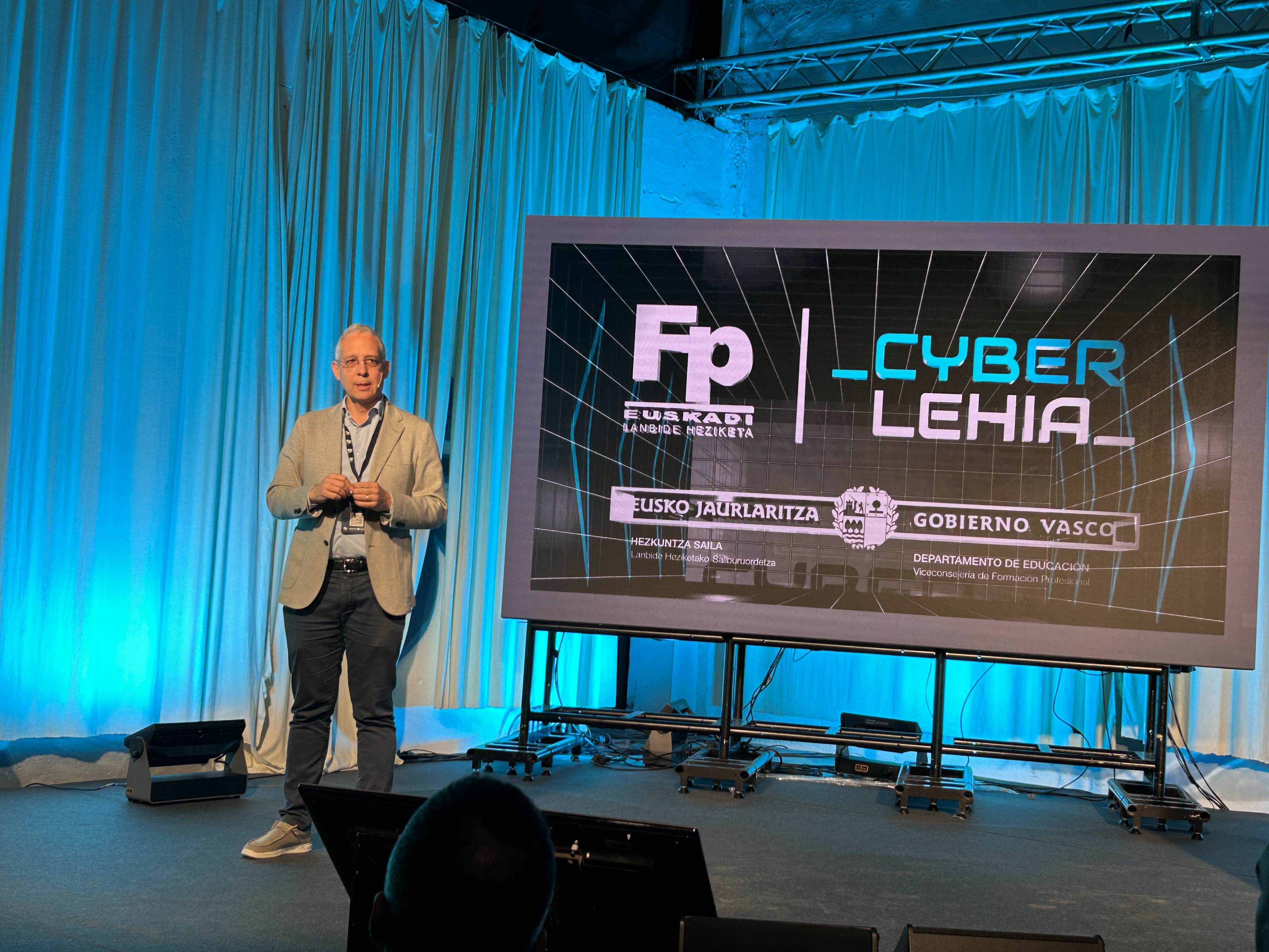 Javier Di&eacute;guez, Director General de Cyberzaintza, delante de una pantalla haciendo una presentaci&oacute;n en la apertura de la final de CyberLehia.