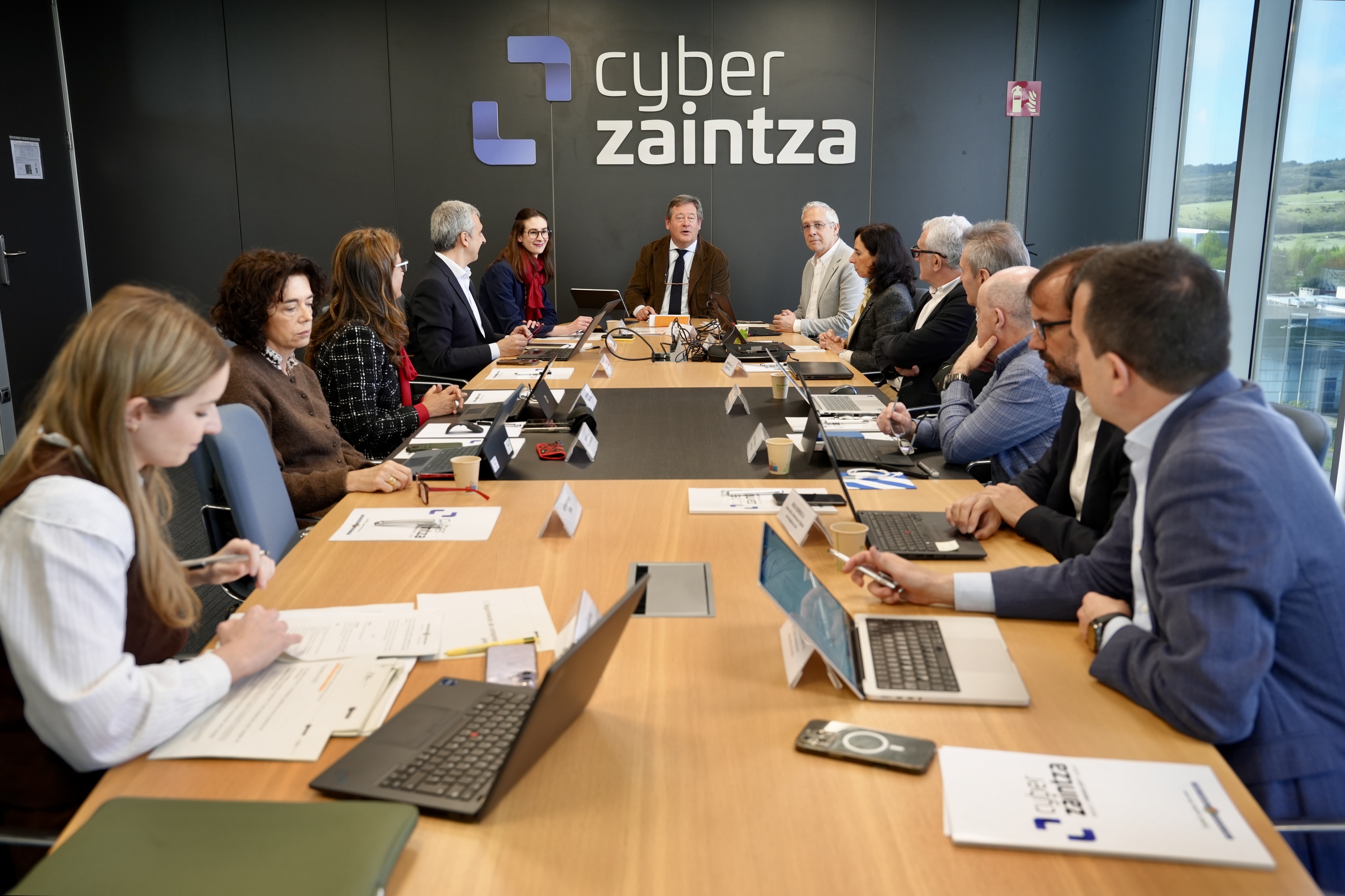 Fotograf�a en la que se ve a los miembros del Consejo de Administraci�n de Cyberzaintza sentados en la mesa de reuniones de la sede de la Agencia Vasca de Ciberseguridad en Mi�ano