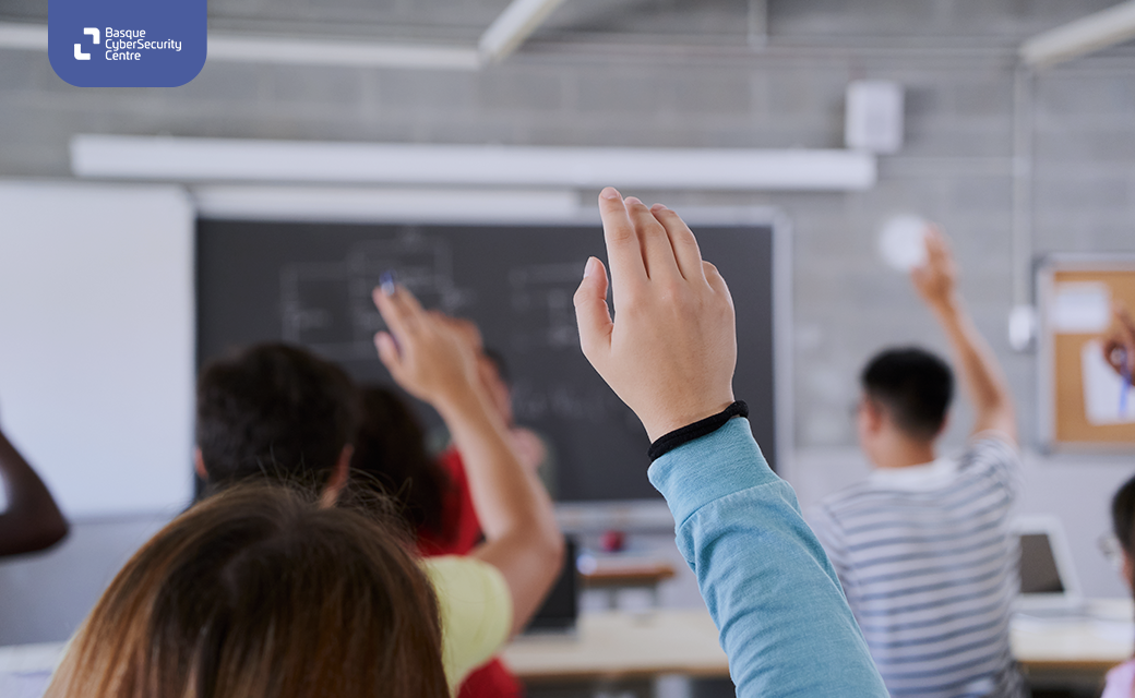 Varios alumnos levantan la mano en un aula, durante un taller de ciberseguridad y ciberbullying.