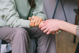 Irudia: bi pertsona beren eskuak estutzen, laguntza-seinale gisa