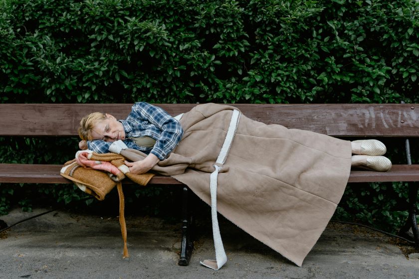 Mujer sin hogar durmiendo en un banco