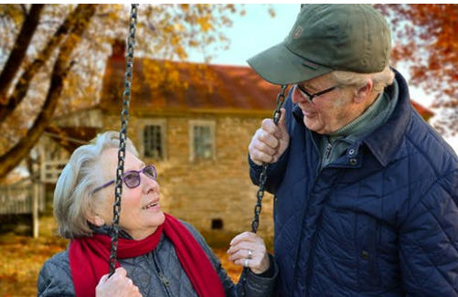 Pareja de ancianos en el exterior de una vivienda
