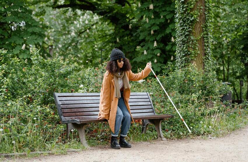 Desgaitasuna duen emakumea parke batean esertzen