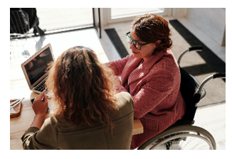 Trabajo en equipo: trabajadora social conversando con mujer en silla de ruedas