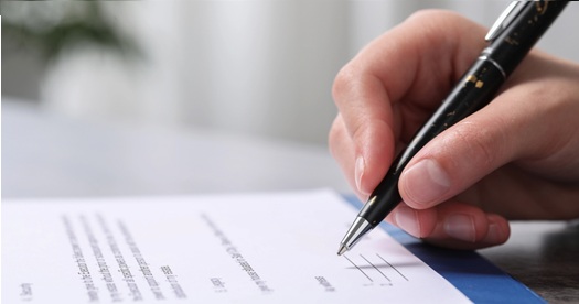 Fotograf�a de una persona leyendo y firmando un documento