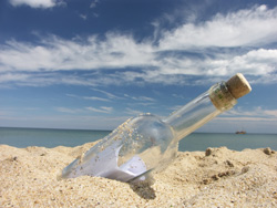 Imagen de botella de cristal en la arena de la playa