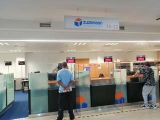 Una trabajadora atiende a una ciudadana en las oficinas de Zuzenean en Bilbao