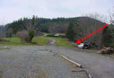 Geziak hilobiaren tokia seinalatzen du, errepide ondoko arekan.